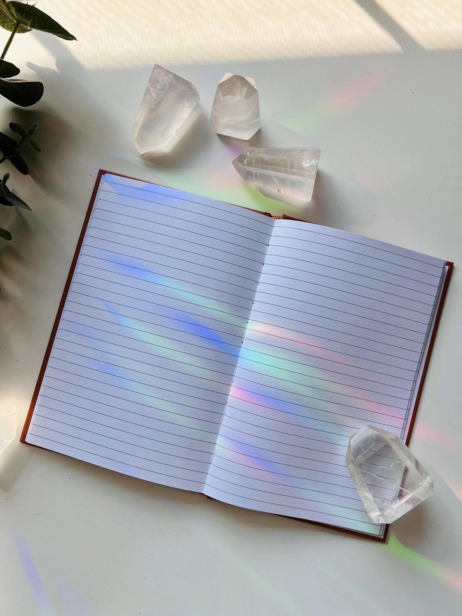Ark Made Mercury Retro Babe Lined Journal opened to blank pages with crystals on the side and sunlight reflections.