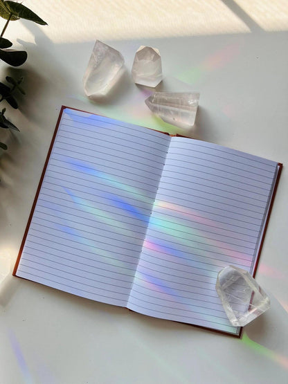 Ark Made Mercury Retro Babe Lined Journal opened to blank pages with crystals on the side and sunlight reflections.