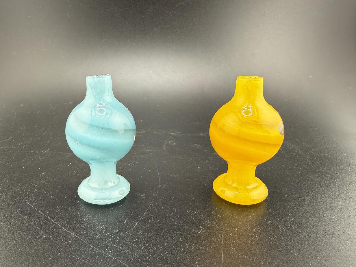 Two colorful Bolt Up Bubble Caps in blue and yellow, designed for enhancing smoking experiences.