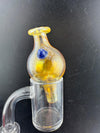Filla John Fumed Bubble Cap on a dab rig, featuring vibrant gold and blue color shift for enhanced airflow control.