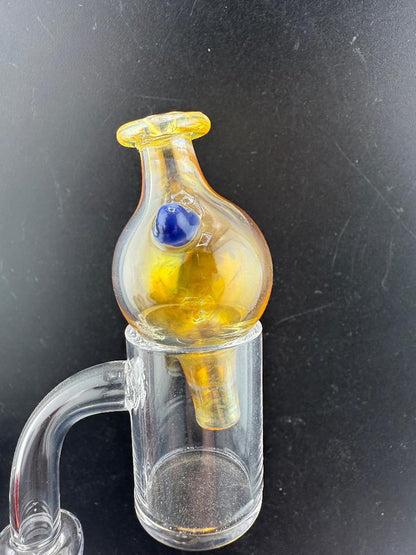 Filla John Fumed Bubble Cap on a dab rig, featuring vibrant gold and blue color shift for enhanced airflow control.