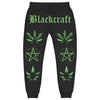 BlackCraft Cult Joggers featuring bold green graphics and occult iconography on a black background.