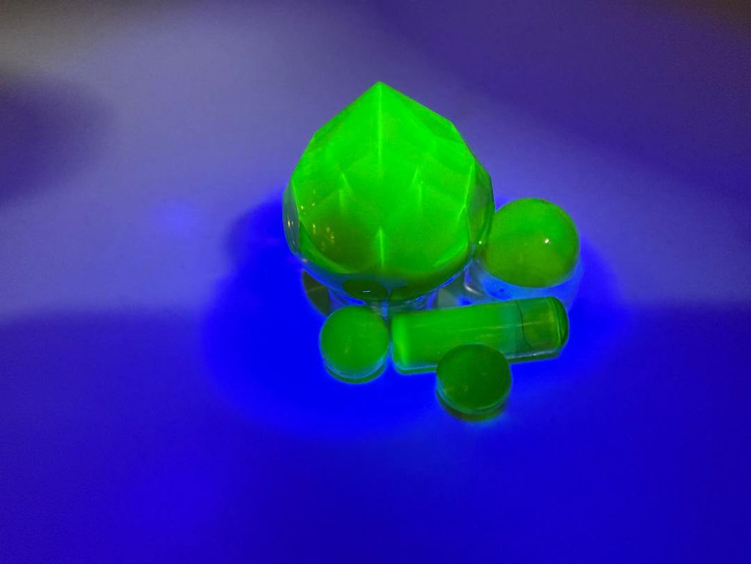 Bowman Glass Faceted Quartz Terp Slurper Set in vibrant green under UV light for an enhanced dabbing experience.