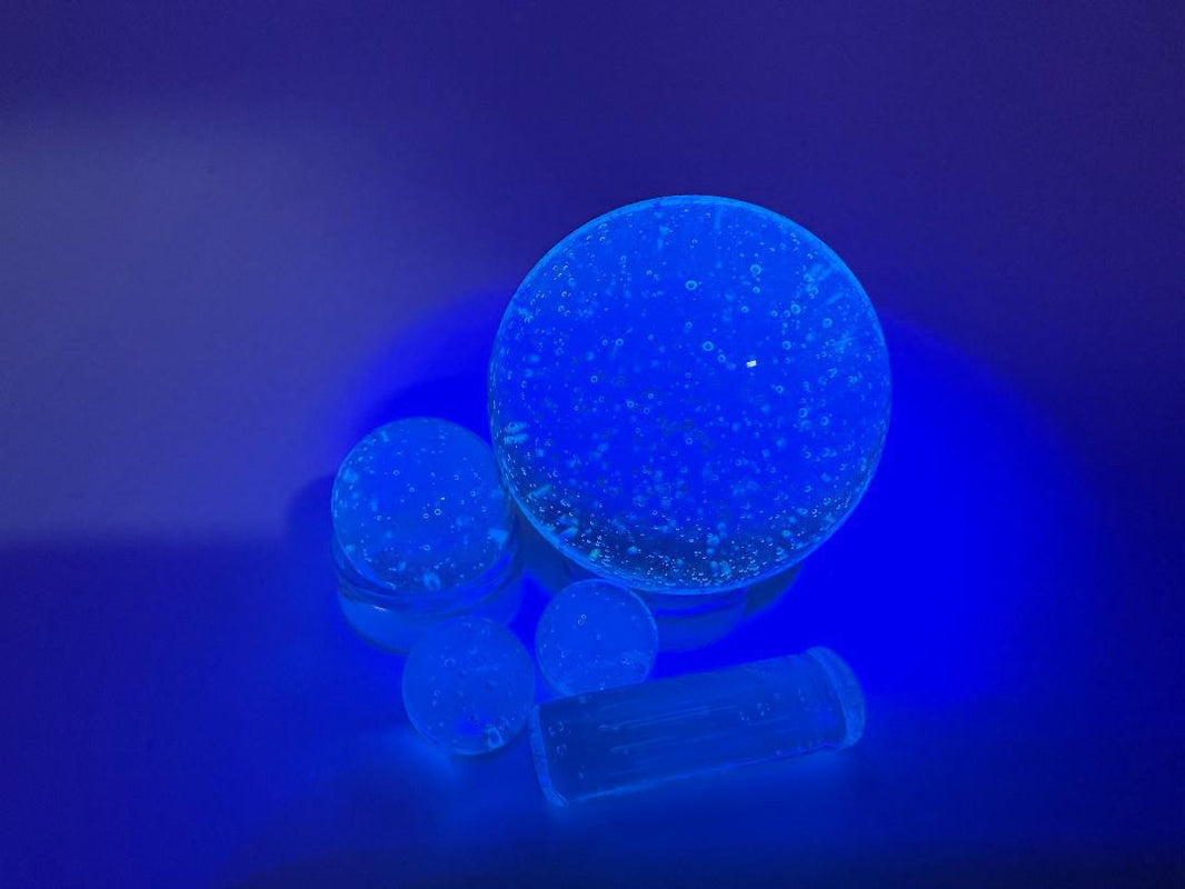 Bowman Glass Oversized Terp Slurper Marble Set, 4 pieces, glowing under UV light, showcasing American borosilicate craftsmanship.