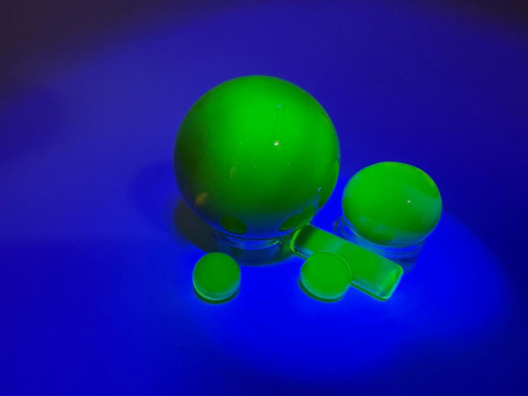 Bowman Glass 4pc Terp Slurper Marble Set glowing green on blue background, showcasing high-quality borosilicate craftsmanship.