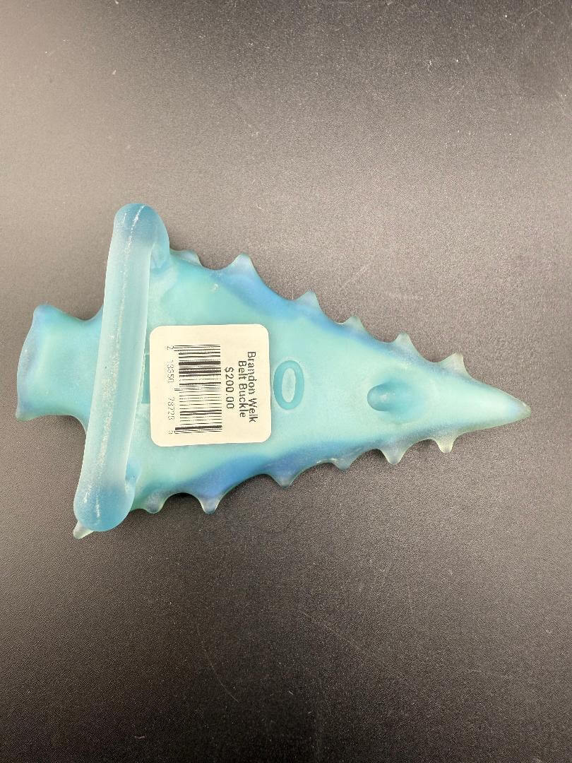 Brando Glass Belt Buckle - Light Blue Sandblasted Arrowhead w/ Mountain & Forest Scene showcased on dark background.