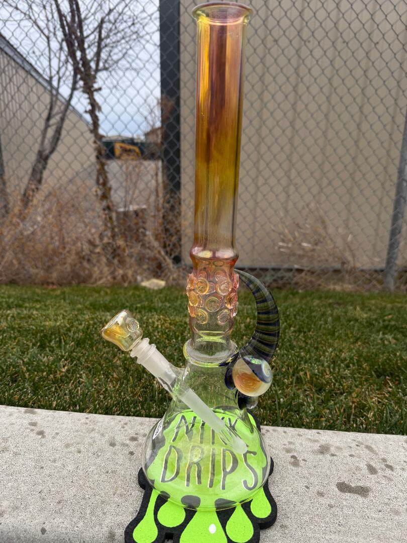 Brando Glass Flower Beaker - 18" Fumed Neck Line Worked Horn 14mm 45° displayed outdoors on grass.