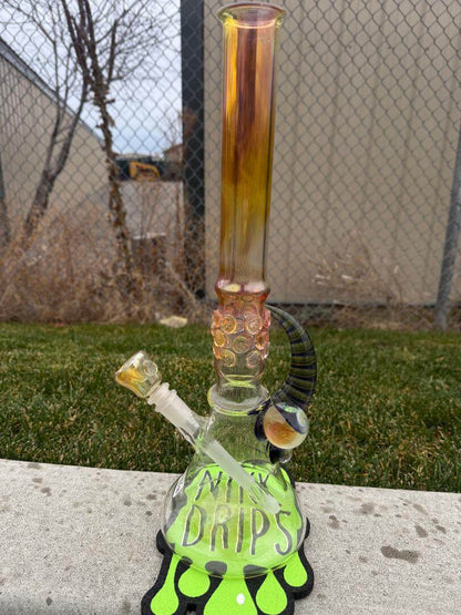 Brando Glass Flower Beaker - 18" Fumed Neck Line Worked Horn 14mm 45° displayed outdoors on grass.