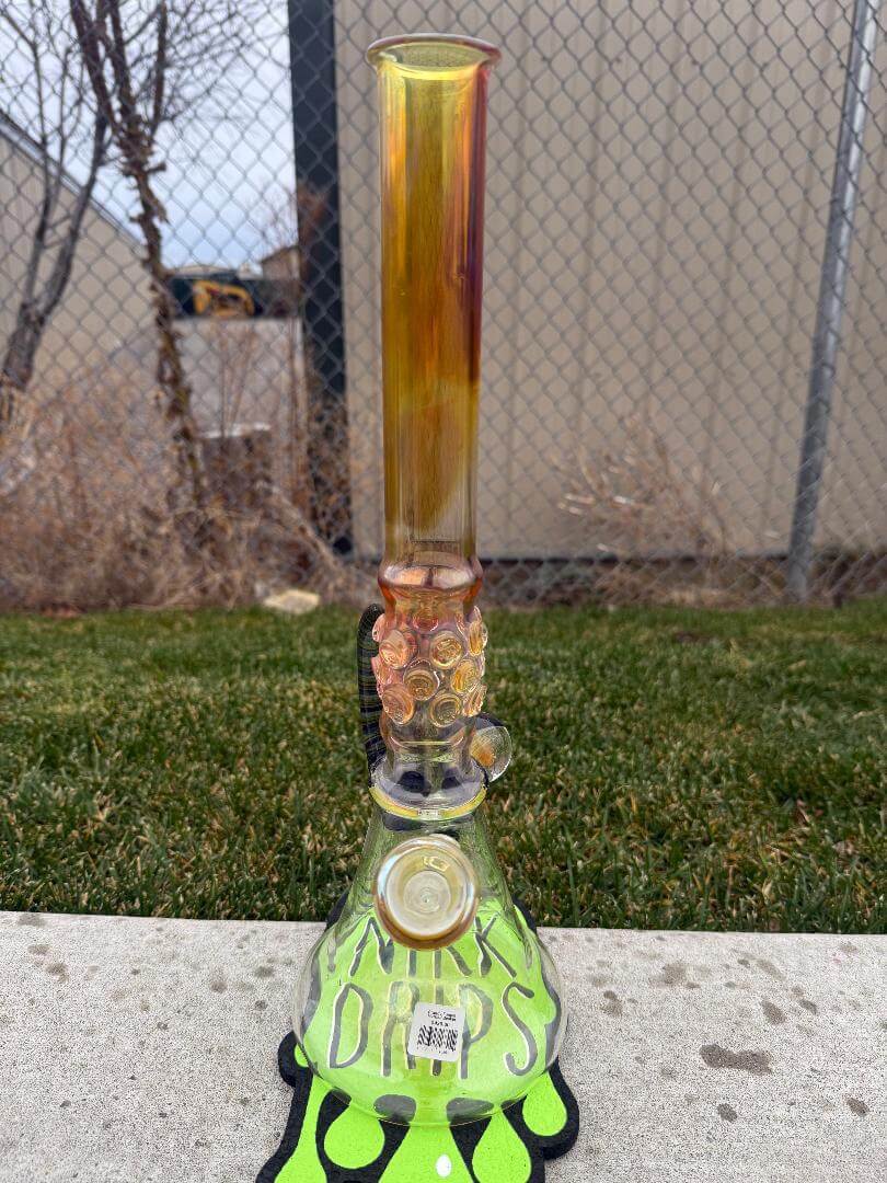 Brando Glass Flower Beaker - 18" Fumed Neck Line Worked Horn 14mm 45° displayed on green mat outdoors.