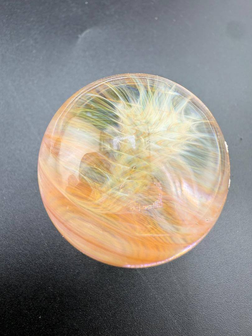 Brando Glass Gold Fumed Marble 1.3" showcasing vibrant colors and swirling designs, handcrafted in Spokane.