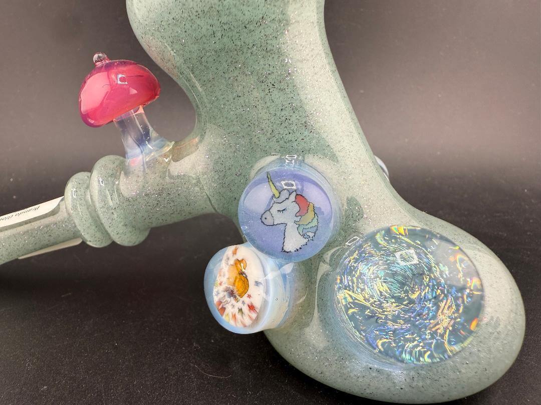 Brando Glass Hammer Pipe - Teal Sparkle UV Glow w/ Pink Mushroom & Rainbow Bright Millies showing colorful millies and details.