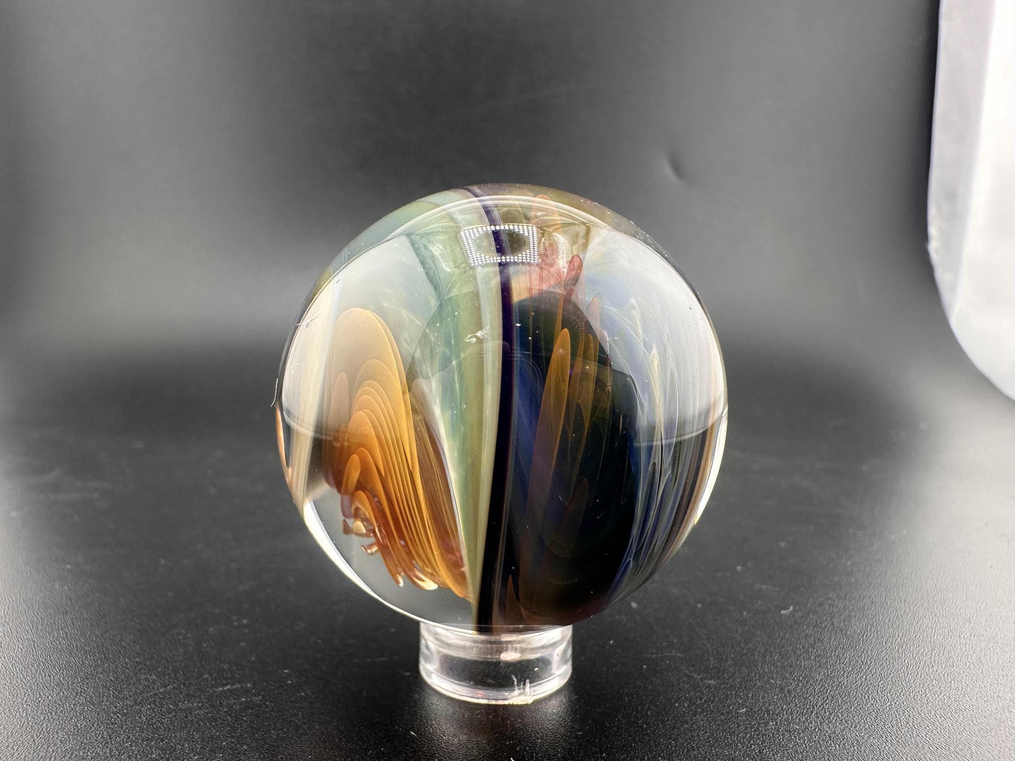 Brando Glass Large Marble - Swirled Backed Implosion showcasing vibrant colors and intricate design on a black background.