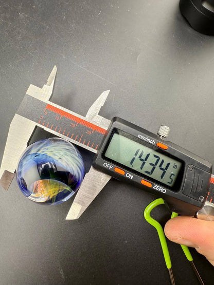 Brando Glass Marble - Double Vortex 1.4" - 1.6" being measured at 14.34 inches with digital caliper.