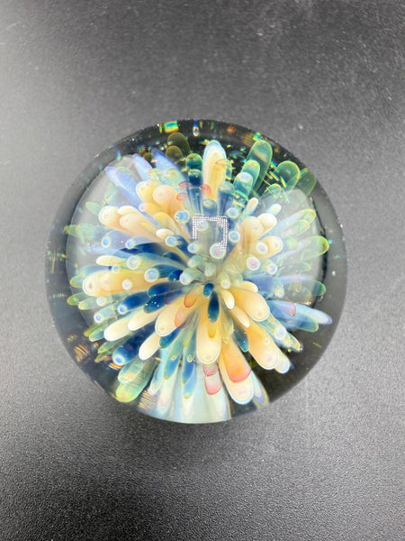 Brando Glass Marble - Frit Implosion Flower w/ Dichro Backer with colorful floral design in glass.