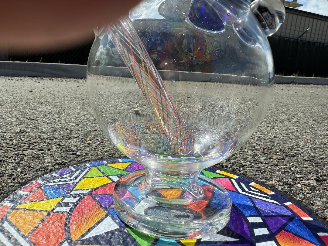 Brando Glass Retti Rainbow Tube close-up on colorful art surface, showcasing vibrant colorwork and precision craftsmanship.