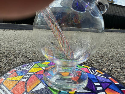 Brando Glass Retti Rainbow Tube close-up on colorful art surface, showcasing vibrant colorwork and precision craftsmanship.