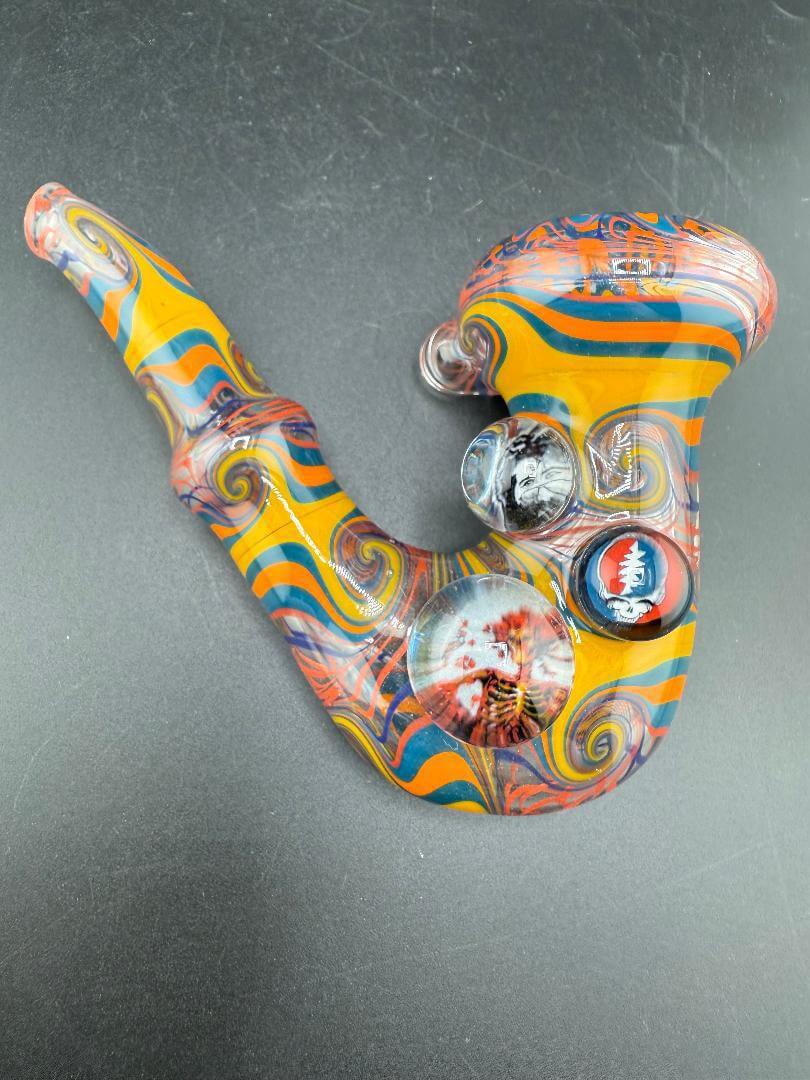 Brando Glass Sherlock Pipe - Orange Yellow & Teal Wig Wag w/ Grateful Dead Millie Attachments on a black background.