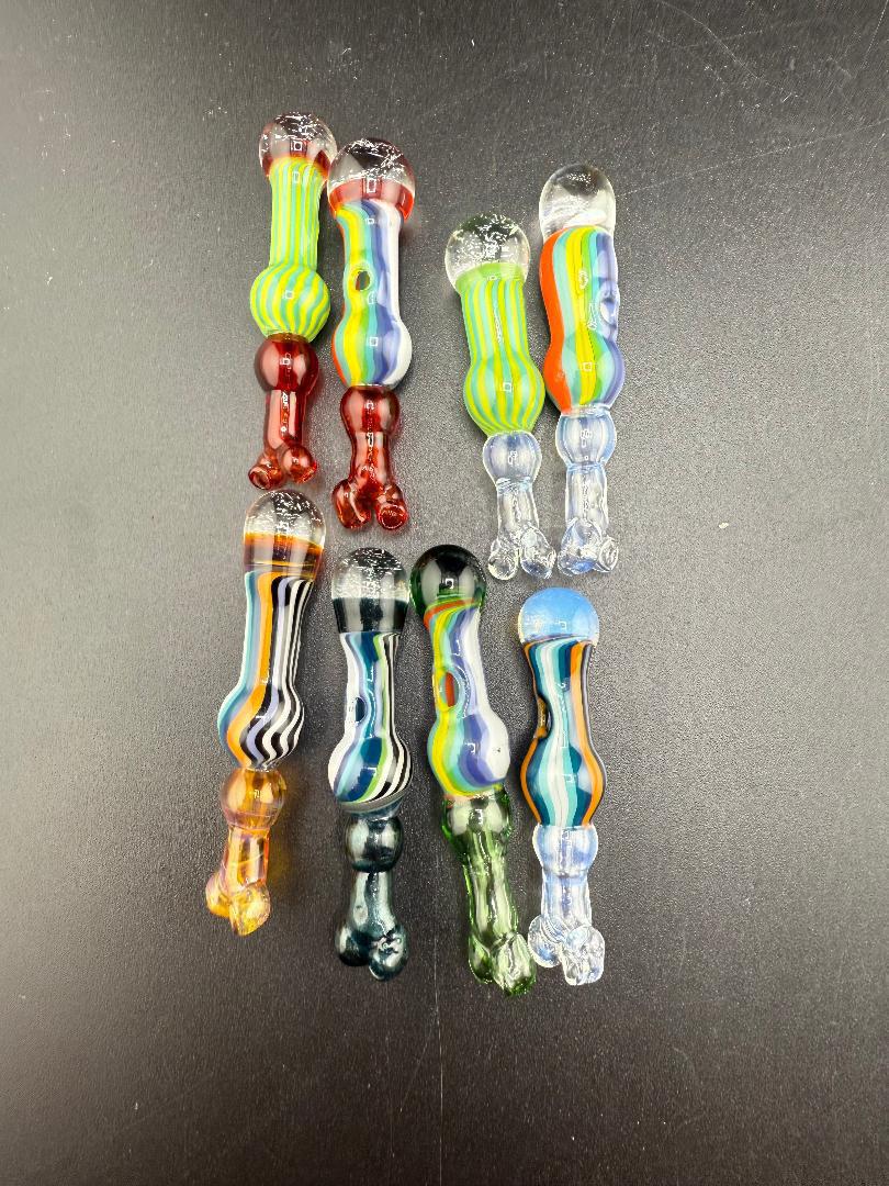 Colorful handblown glass pieces in various designs and colors, showcasing unique patterns and aesthetics.