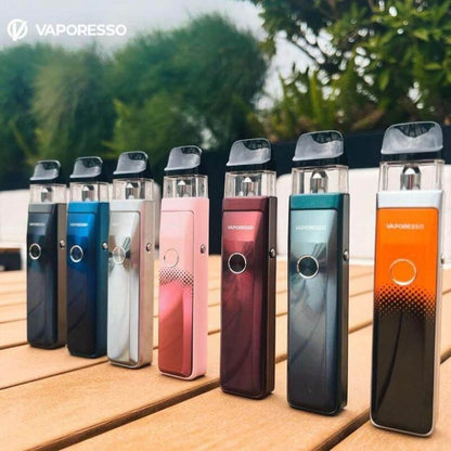 Vaporesso XROS Pro pod systems in various colors displayed on a wooden table outdoors.