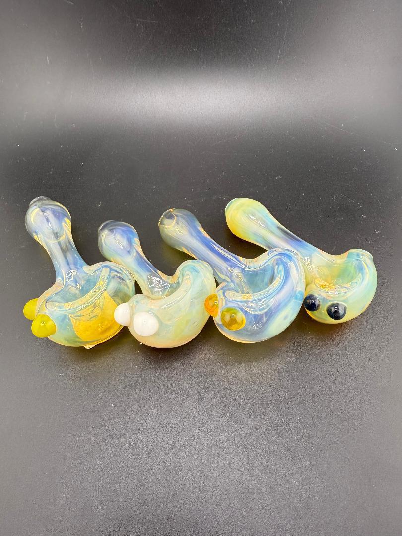 Handcrafted glass pipes with fumed finish and colorful accents, showcasing unique designs by local artists.