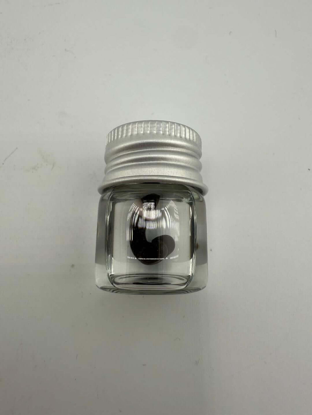 Clear glass container with silver lid and heart shape design inside, ideal for dab accessories.