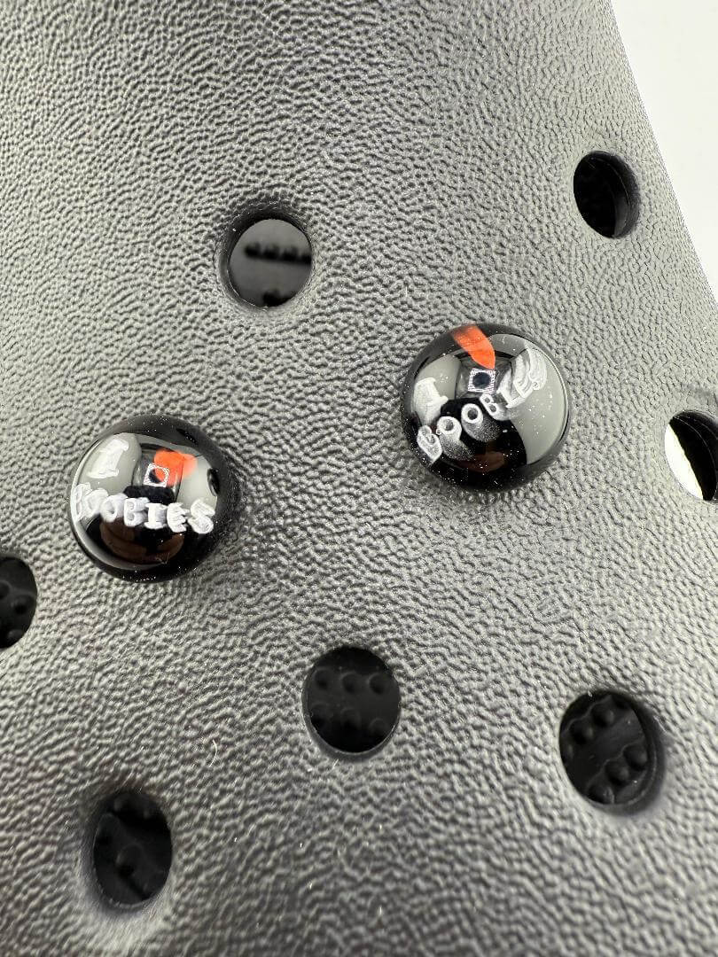 Close-up of two black glass buttons reading 'Cool' and 'Boo', set against a textured surface.