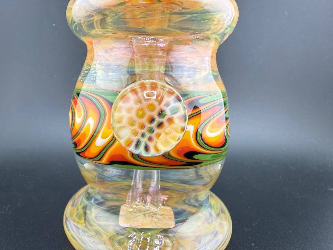 Colorful handcrafted glass rig with vibrant linework and unique honeycomb design, perfect for dabbing.
