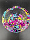 Cookies Glass Ashtray with colorful design featuring the iconic Cookies logo and cannabis leaf patterns.