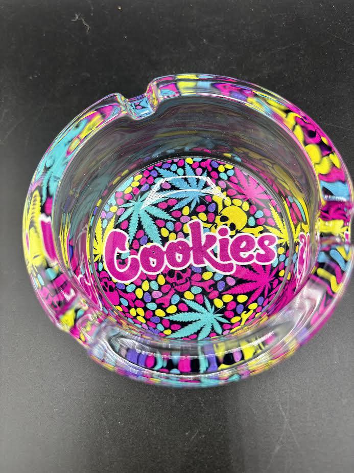 Cookies Glass Ashtray with colorful design featuring the iconic Cookies logo and cannabis leaf patterns.