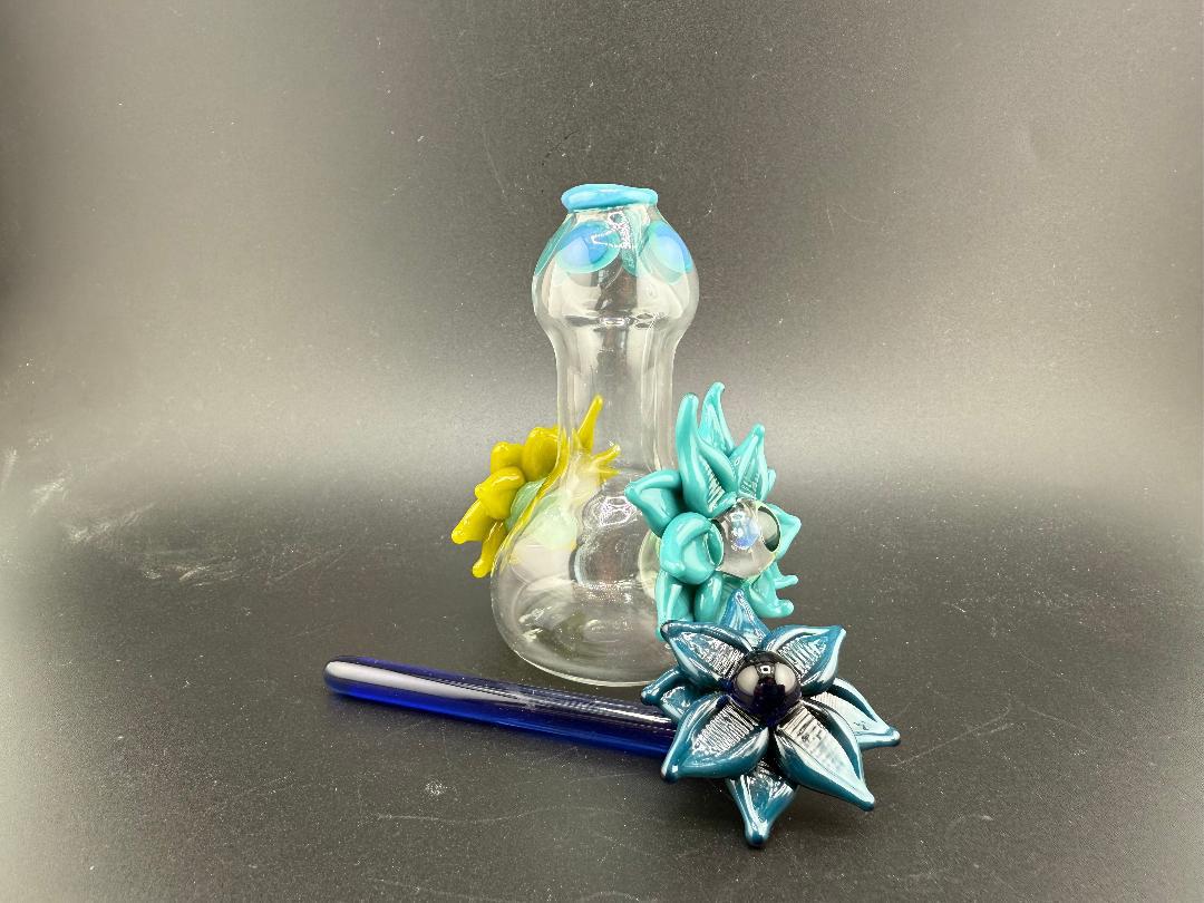Pablos Glass Flower Jar with colorful flower designs, featuring a blue and yellow glass accent and a matching spoon.