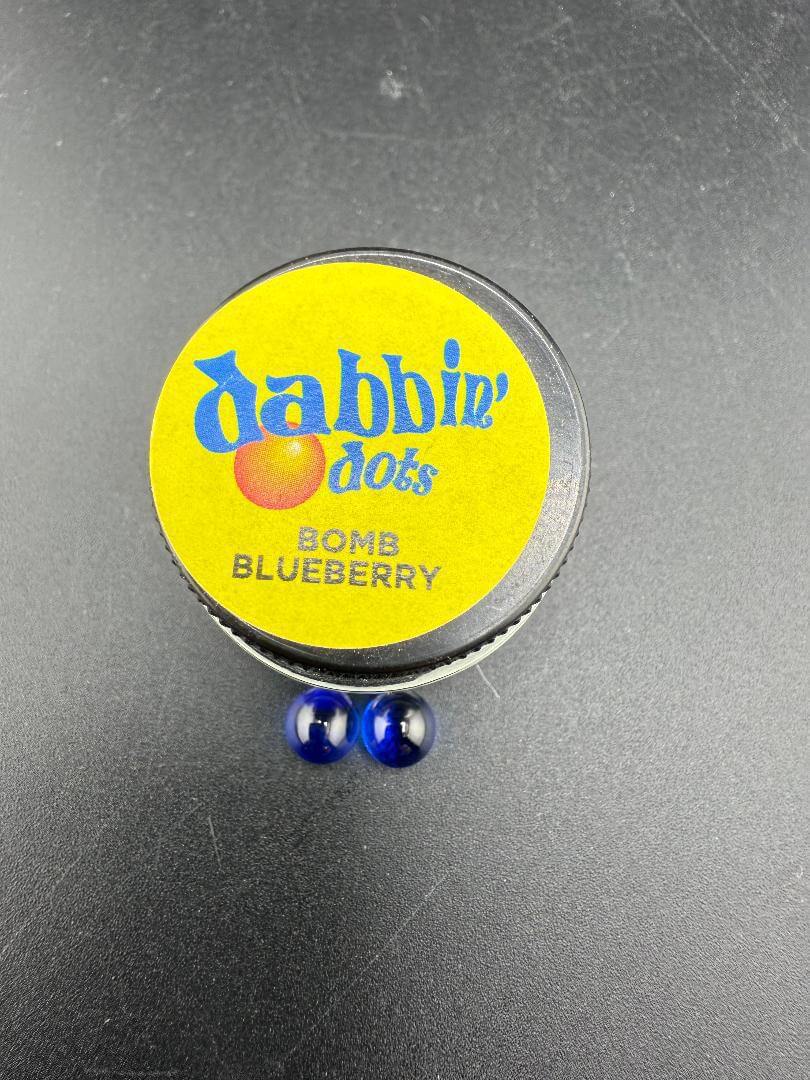 Dabbing Dots - Terp Pearls in a container labeled Bomb Blueberry, featuring two blue glass pearls.