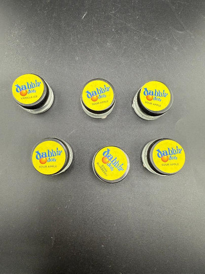 Dabbing Dots - Terp Pearls in various flavors including Sour Apple and Vanilla Ice, displayed on a black surface.