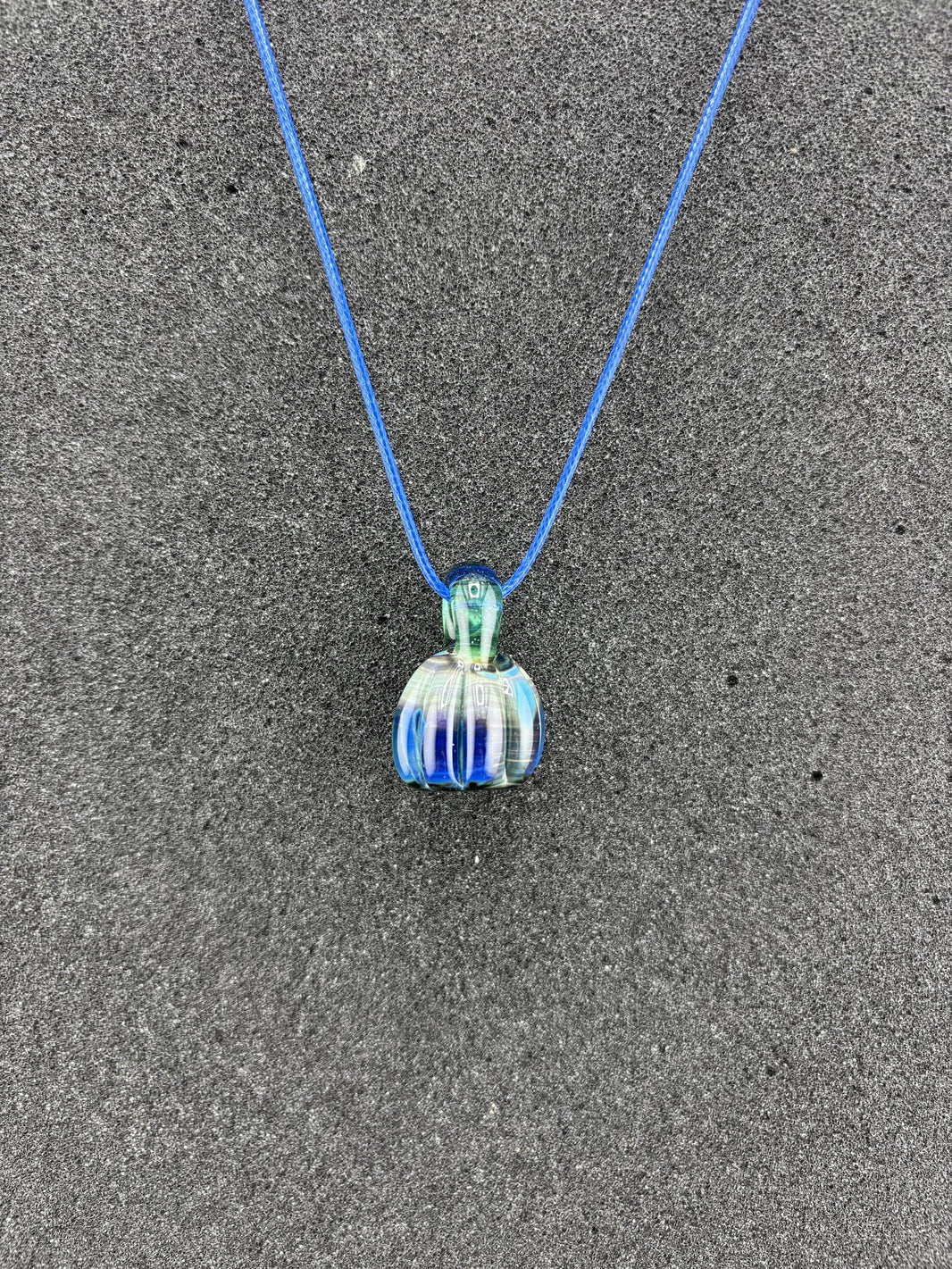 Danny W Pumpkin Pendant - Blue handcrafted pendant on a blue cord, showcasing whimsical autumn charm.