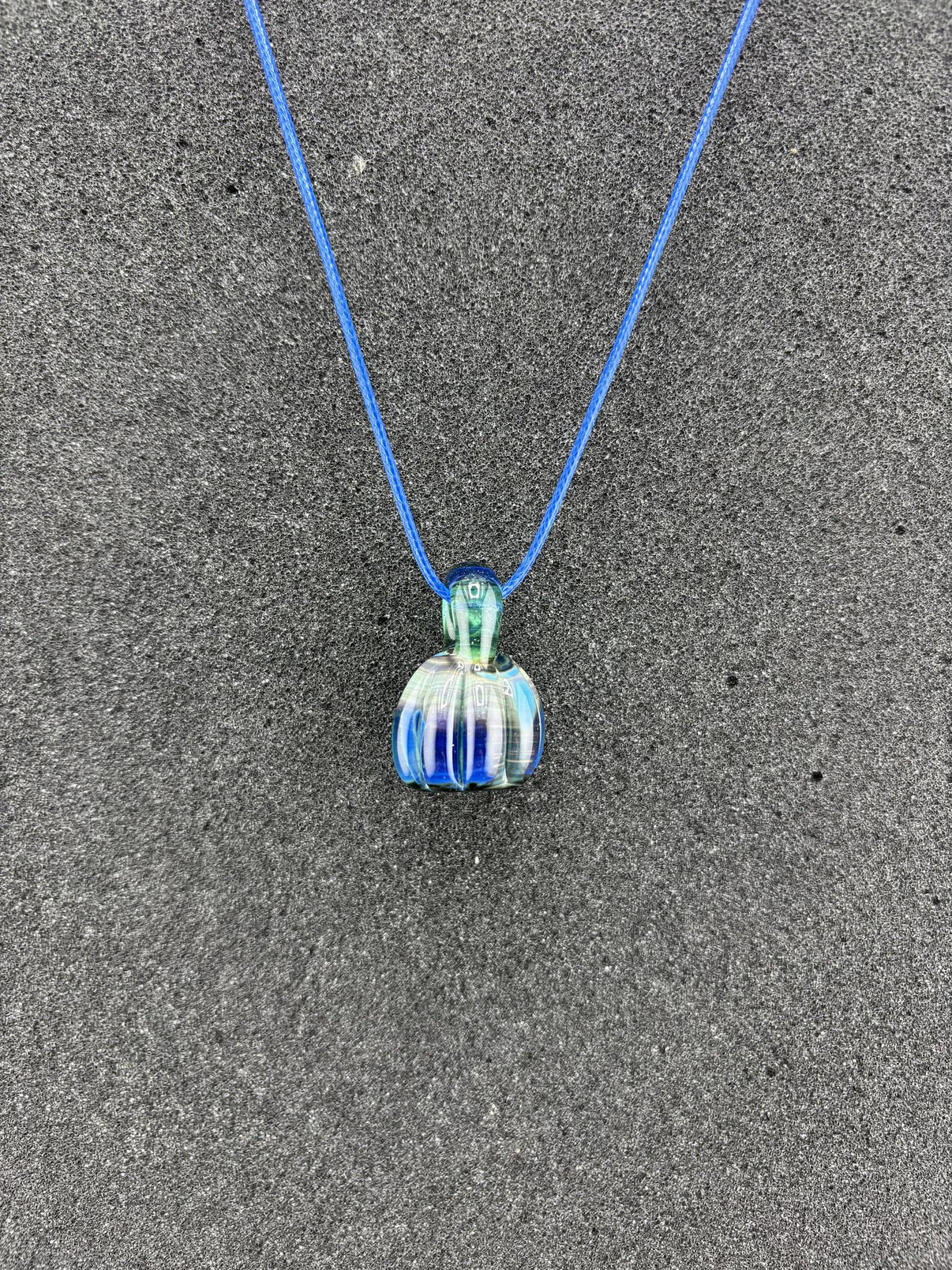 Danny W Pumpkin Pendant - Blue handcrafted pendant on a blue cord, showcasing whimsical autumn charm.