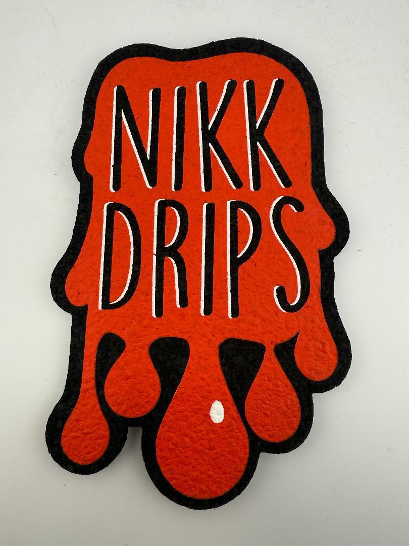 MoodMats x Nikk Drips classic logo design in orange and black, highlighting unique drips style.