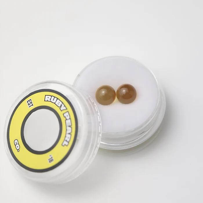 Ruby Pearl Co Yellow Sapphire Terp Pearls in clear container for dabbing, enhancing flavor and vapor production.
