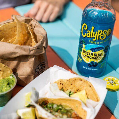 Ocean Blue Lemonade by Calypso paired with tacos and tortilla chips on a colorful table.