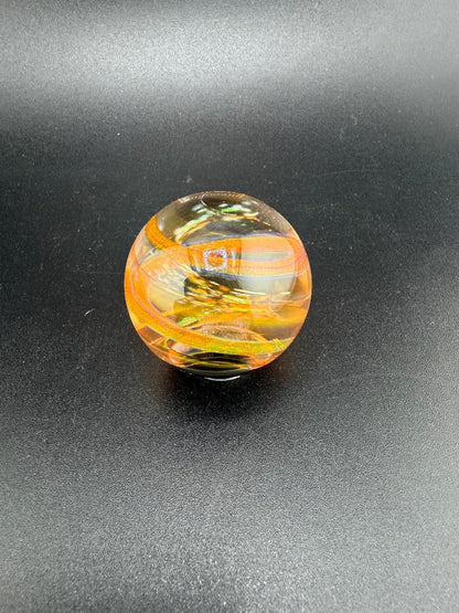 Doc Glass Fumed Marble 1" Marble showcased on a black surface, highlighting its intricate swirling patterns and vibrant colors.