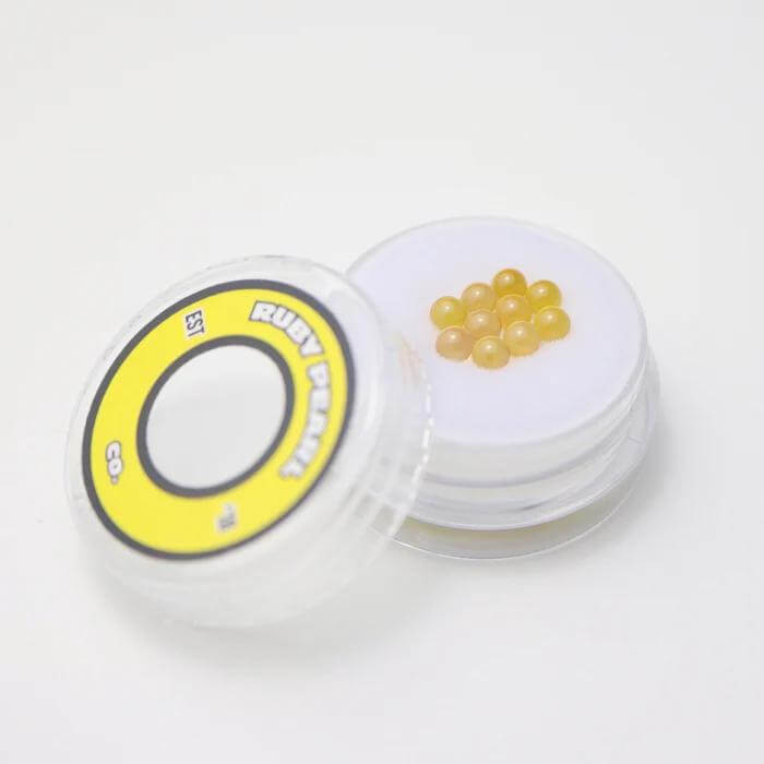 Ruby Pearl Co Yellow Sapphire Terp Pearls in clear container for superior dabbing experience and enhanced flavor.