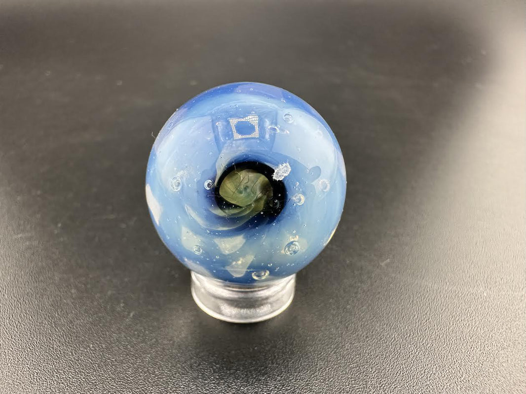 Elbow Tim Glass Fume Chaos Marble showcasing a swirling blue design, handcrafted glass art approximately 1 inch in diameter.