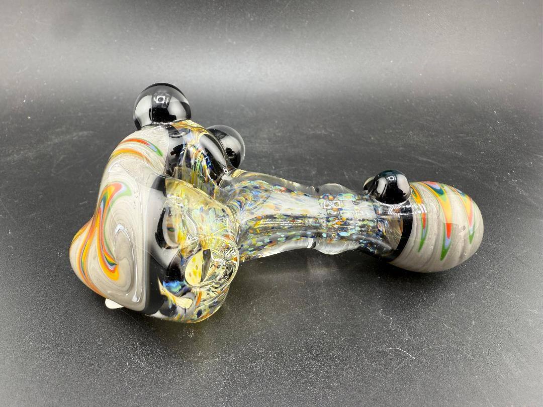 Elbow Tim Glass Hand Pipe - Fumed w/ Rainbow Wig wag Cap, Accents , & Marble Attachments on a black background.
