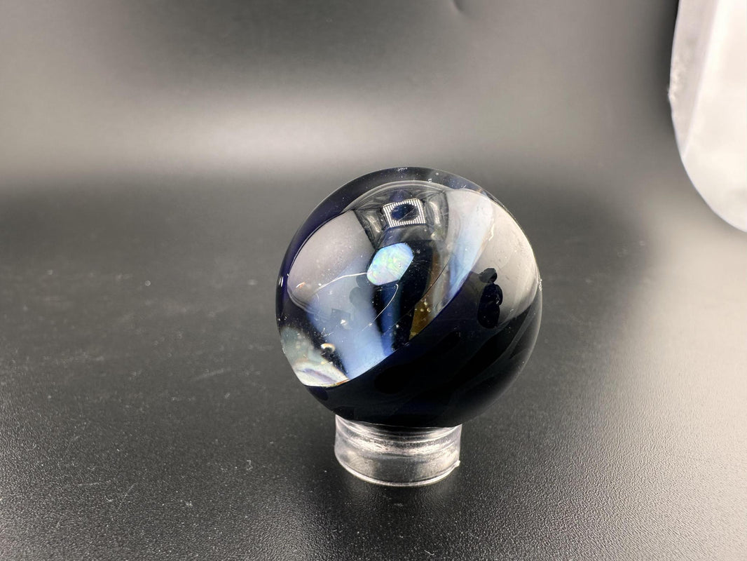 Elbow Tim Glass Marble - Opal Vortex showcasing a stunning vortex design with suspended opal at its core.