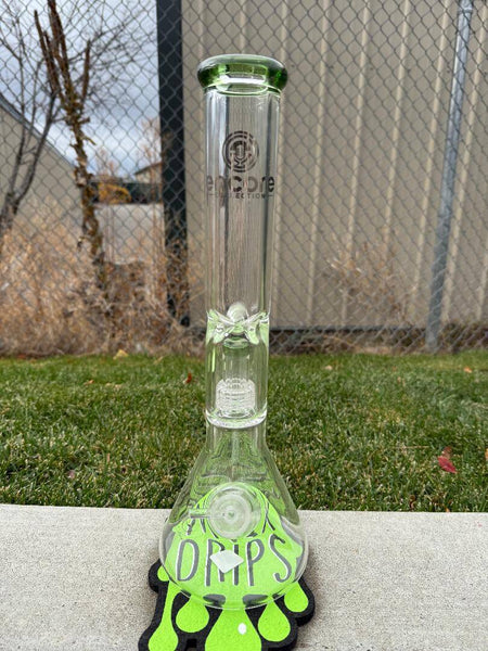 Encore Glass 16" Matrix Perk Beaker 14mm 90° standing on grass next to green drip-themed coaster.