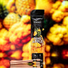 CAMO Natural Leaf Cones King Size Pineapple flavor package with pre-rolled cones in front of vibrant pineapple background.