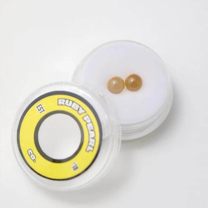 Ruby Pearl Co Yellow Sapphire Terp Pearls in a clear case for enhanced dabbing performance and flavor.