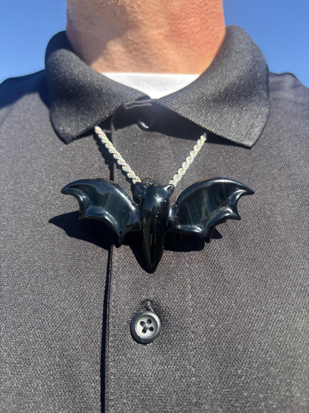 Filla John Bat Pendant worn on a black shirt, showcasing its unique handcrafted design and detailed bat shape.