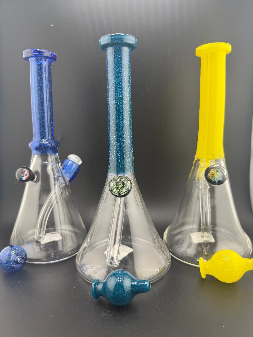 Filla John Glass Dichro Neck Single Color Beaker 10mm 45° trio of vibrant hand-blown glass bongs in blue, teal, and yellow.