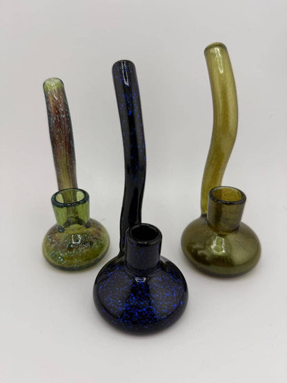 Three handcrafted glass dry rigs in varied colors and designs featuring dichroic accents and unique shapes.