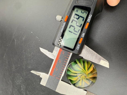 Filla John Glass Marble - Fumed Implosion Approx. 1.25" with measuring tool showing size.