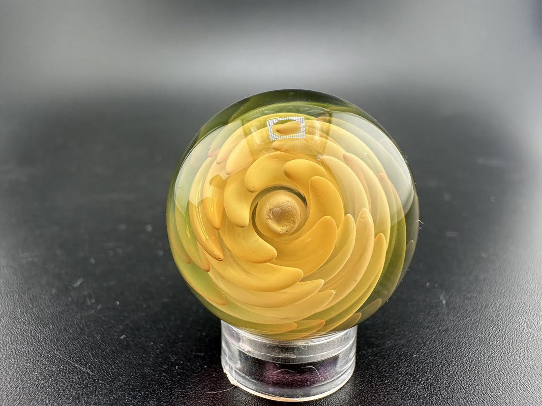 Filla John Glass Fumed Marble handcrafted glass art marble with intricate yellow and green design elements.